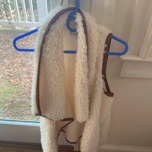 Cozy fur vest lined in brown leather with pockets.